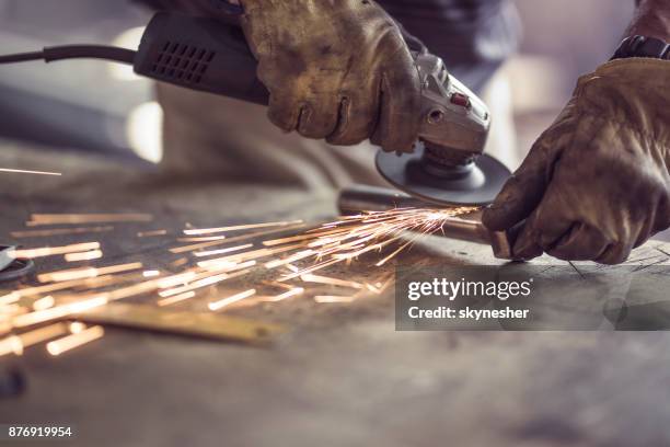 onherkenbaar arbeider snijden ijzer met een zaag aan een workshop. - grinder stockfoto's en -beelden