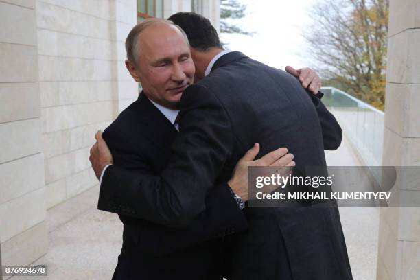 Russia's President Vladimir Putin embraces his Syrian counterpart Bashar al-Assad during a meeting in Sochi on November 20, 2017.