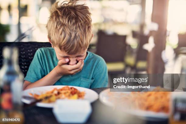 petit garçon va pour être malade au restaurant - mépris photos et images de collection