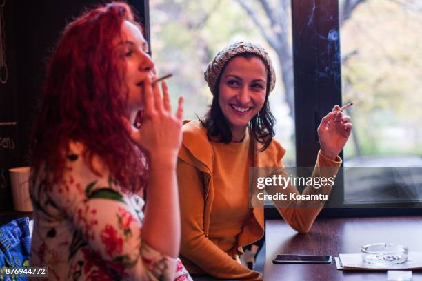 friends chatting on quayside on autumn day - friends smoking stock pictures, royalty-free photos & images