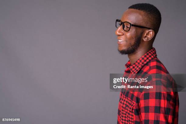 studio portrait of young handsome black african man with short hair and beard wearing colorful clothes - glasses side profile stock pictures, royalty-free photos & images