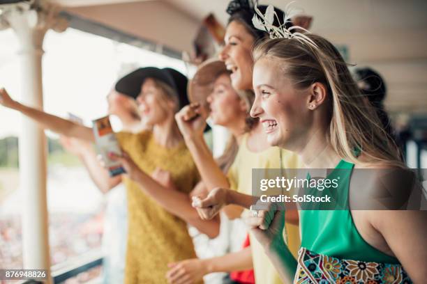 grupo de mujeres jóvenes - moda femenina en las carreras de caballos fotografías e imágenes de stock