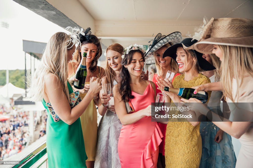 Groep van jonge vrouwen, een fles Champagne openen