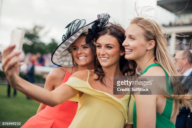 joven mujer tomando un autorretrato - moda femenina en las carreras de caballos fotografías e imágenes de stock
