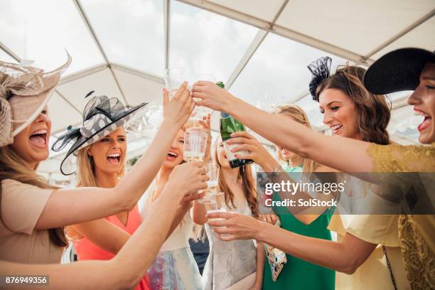 gieten van champagne met vrienden - derby day stockfoto's en -beelden