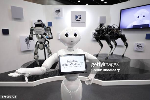 SoftBank Group Corp. Pepper humanoid robot, center, stands in front of a Boston Dynamics Inc. Atlas humanoid robot, left, and Spot robot as they are...