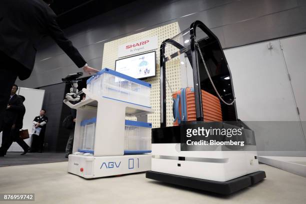Sharp Corp. AGV robot, left, and porter robot stand on display at the SoftBank Robot World 2017 in Tokyo, Japan, on Tuesday, Nov. 21, 2017. SoftBank...