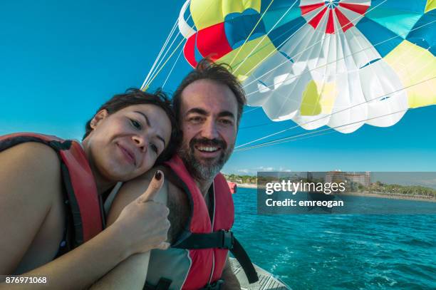 lovely couple before parasailing - emreogan stock pictures, royalty-free photos & images