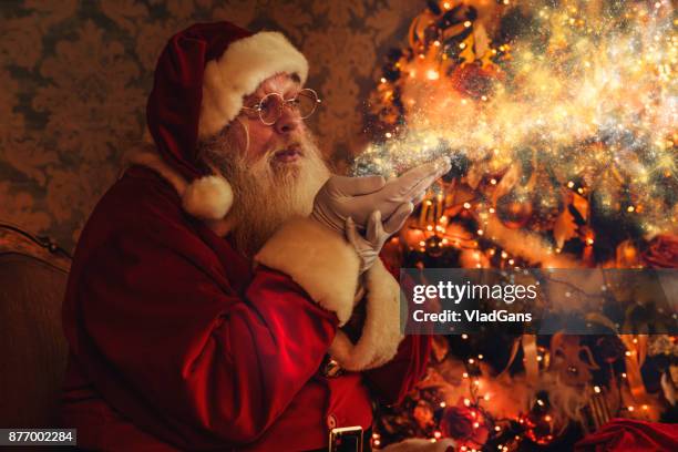 santa blowing magic christmas stars - magical equipment stock pictures, royalty-free photos & images