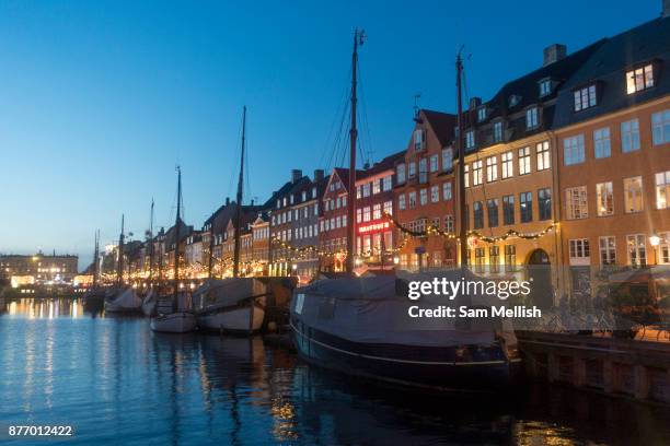 Dusk at Nyhavn on the 18th November 2017 in Copenhagen, Denmark. Nyhavn is a 17th-century waterfront, canal and entertainment district in Copenhagen....