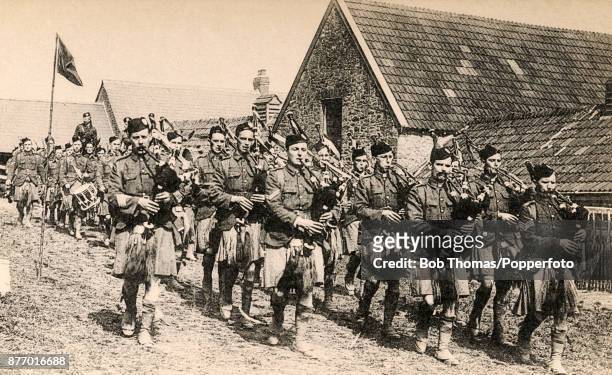 The Scottish Band march and play through a French village during World War One, circa 1918.