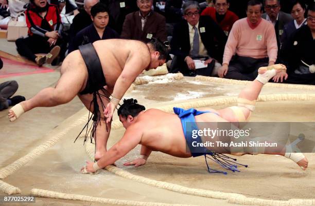 Ozeki Takayasu jumps to fend off as he throws Kotoshogiku to win during day ten of the Grand Sumo Kyushu Tournament at Fukuoka Convention Center on...