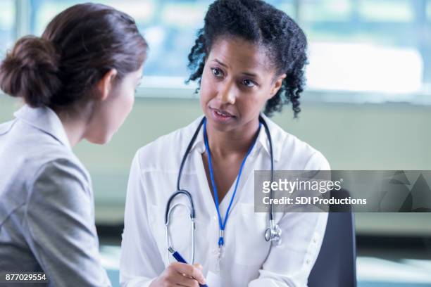 psychiatre écoute patiente avec compasssion - adult patient with doctor and stethoscope photos et images de collection
