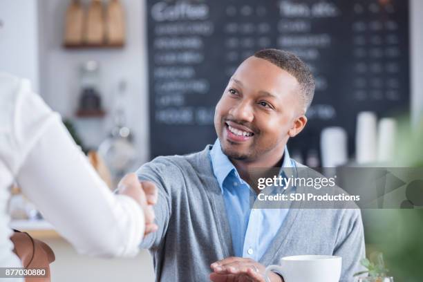 businessman meets interviewee in coffee shop - sneering stock pictures, royalty-free photos & images