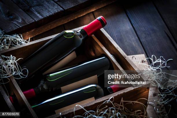 red wine bottles packed in a wooden box shot rustic wooden table - crate stock pictures, royalty-free photos & images