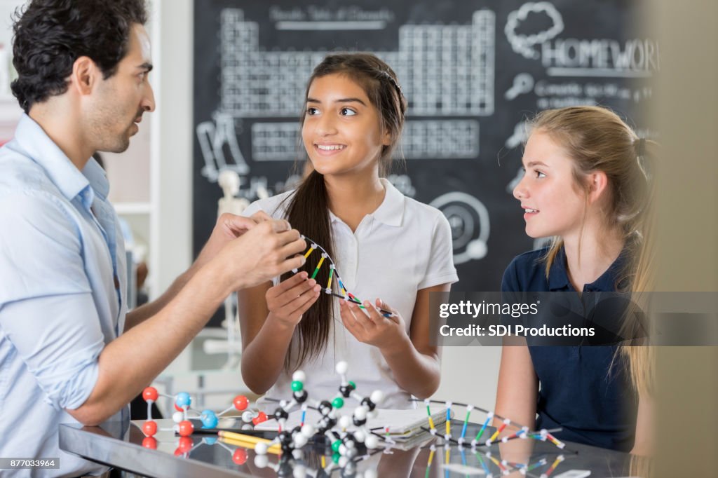Confident junior high teacher works with students in science lab