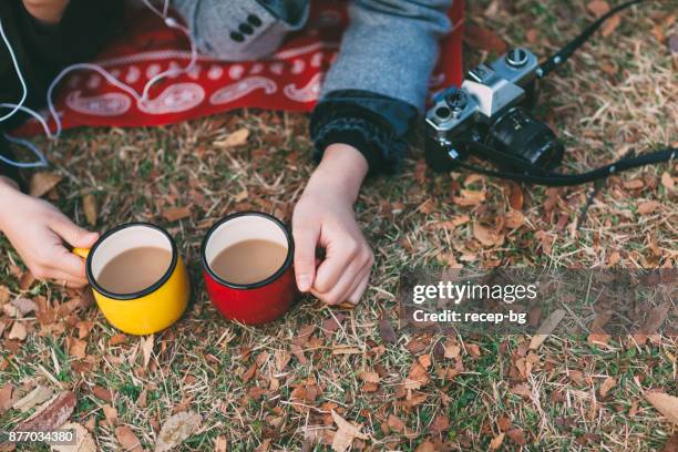 two women holding tea mug - tea mug stock pictures, royalty-free photos & images