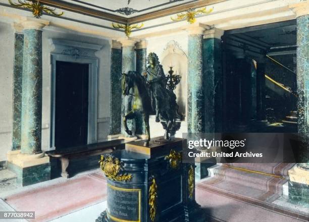 Through three portals you enter the lobby of Linderhof Castle. In the middle inexplicably stands an equestrian statue of Louis XIV of France in...