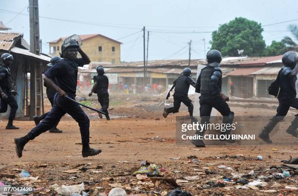 Guinean police officers runs to disperse protesters in a district of Conakry on November 21, 2017. Thousands of schoolchildren in Guinea descended...