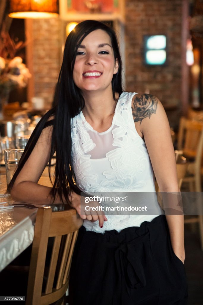 Portrait of woman in smart casual clothes in a bar.