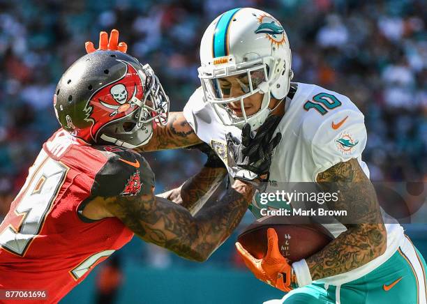 Kenny Stills of the Miami Dolphins stiff arms Ryan Smith of the Tampa Bay Buccaneers in the first quarter at Hard Rock Stadium on November 19, 2017...