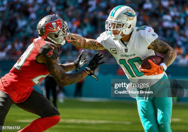 Kenny Stills of the Miami Dolphins stiff arms Ryan Smith of the Tampa Bay Buccaneers in the first quarter at Hard Rock Stadium on November 19, 2017...