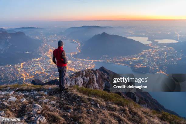 escursionisti in cima alla montagna sopra la città - paesaggio della lombardia foto e immagini stock