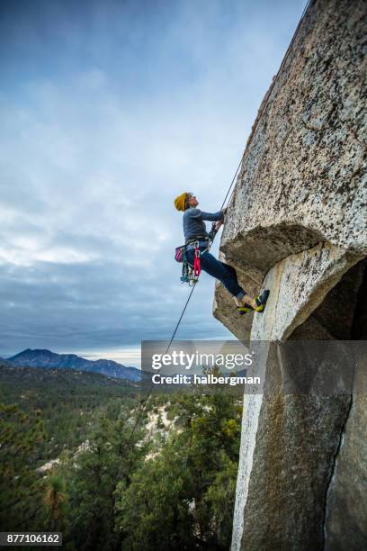 colpo profilo di rock climber che naviga sopraso sporgenza - rock overhang foto e immagini stock