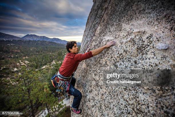 escalador de roca, llegando hasta - escalada en roca fotografías e imágenes de stock