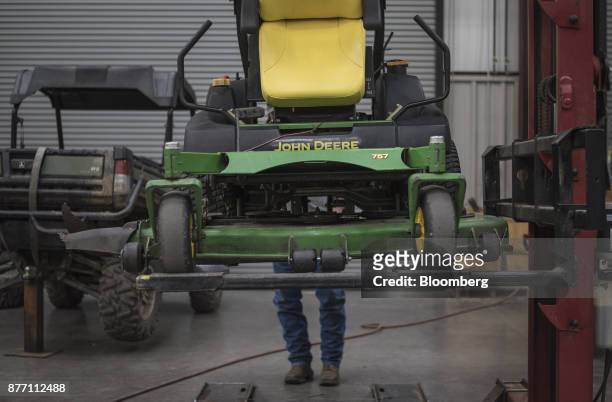 Mechanic lowers a Deere & Co. John Deere 757 lawn mower at a United Ag & Turf dealership in Waco, Texas, U.S., on Monday, Nov. 20, 2017. Deere & Co....