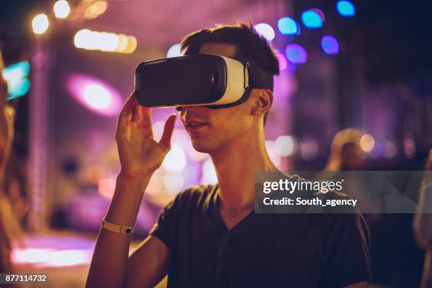 man wearing virtual reality glasses at music festival - interactivity stock pictures, royalty-free photos & images