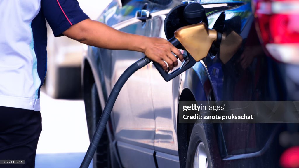 Car refueling on a petrol station and Employees filling .
