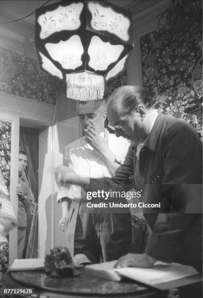 Italian film director Roberto Rossellini with Vittorio De Sica during the movie 'General della Rovere' 1959. Rossellini talks and directs the actors.