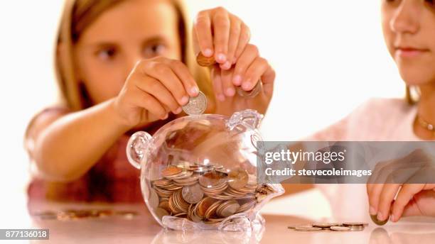 kleine mädchen sparschwein münzen inbetriebnahme. - spardose stock-fotos und bilder
