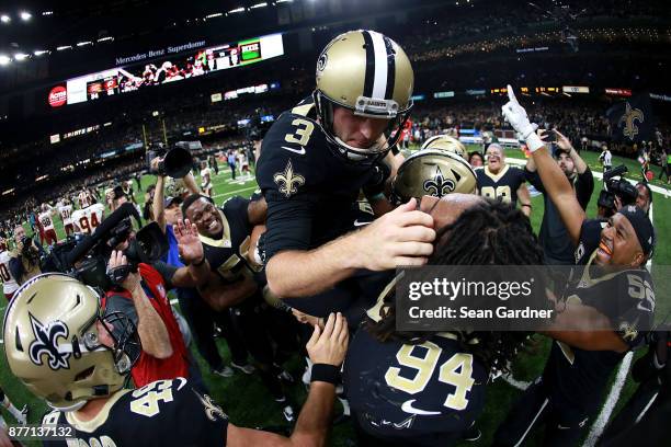 Wil Lutz of the New Orleans Saints is hoisted into the air aftet kicking a game wining field goal against the Washington Redskins during a NFL game...