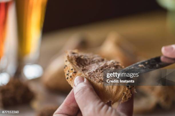 woman spreading boar terrine on a slice of sesame baguette. - pates stock pictures, royalty-free photos & images