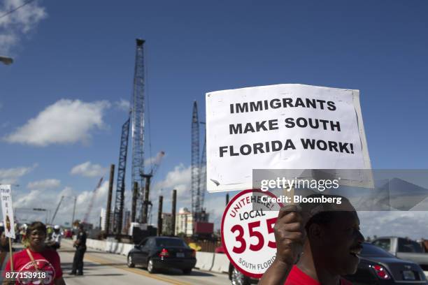 Demonstrator holds a sign during a protest ahead of the arrival of U.S. President Donald Trump at Mar-a-Lago in West Palm Beach, Florida, U.S., on...