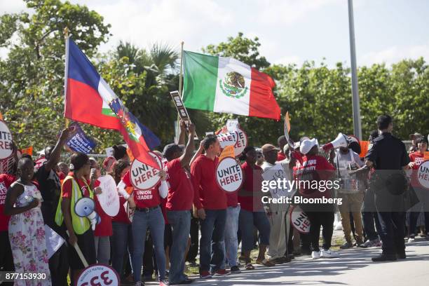 Demonstrators hold signs and wave flags during a protest ahead of the arrival of U.S. President Donald Trump at Mar-a-Lago in West Palm Beach,...