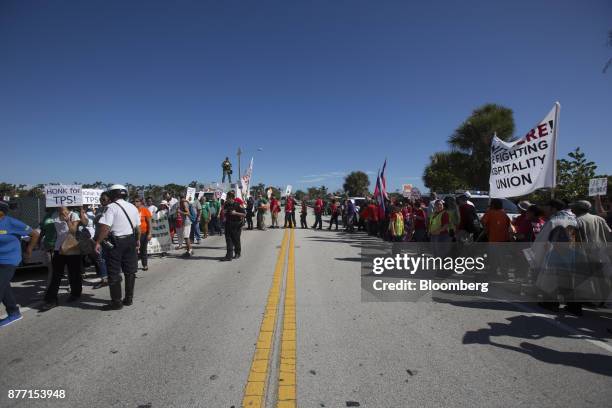 Demonstrators hold signs and wave flags during a protest ahead of the arrival of U.S. President Donald Trump at Mar-a-Lago in West Palm Beach,...