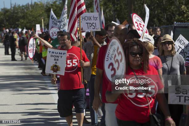 Demonstrators hold signs and wave flags during a protest ahead of the arrival of U.S. President Donald Trump at Mar-a-Lago in West Palm Beach,...