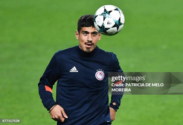 Olympiacos' defender Dimitris Nikolaou heads the ball during a training session at Alvalade stadium in Lisbon on November 21, 2017 on the eve of the...