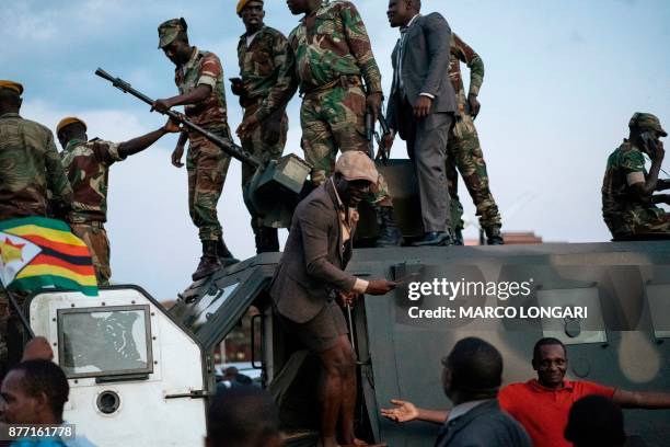 Zimbabwean soldiers are celebrated by citizens in the streets in Harare, on November 21, 2017 after the resignation of Zimbabwe's president Robert...