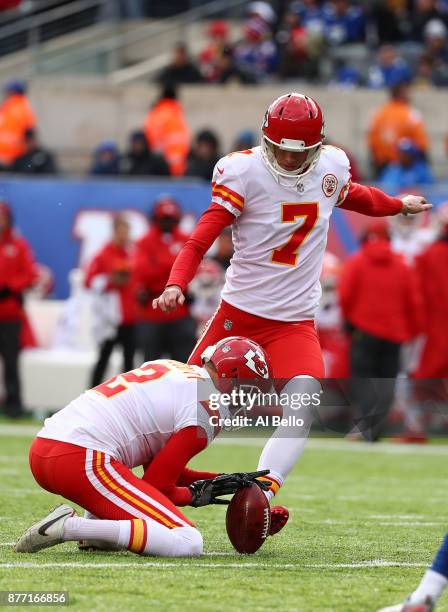 Harrison Butker of the Kansas City Chiefs kicks with Dustin Colquitt holding the ball against the New York Giants during their game at MetLife...