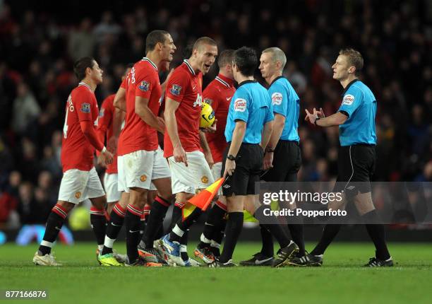 Nemanja Vidic of Manchester United along with the rest of his team mates complains to assistant referee John Flin and referee Michael Jones after the...