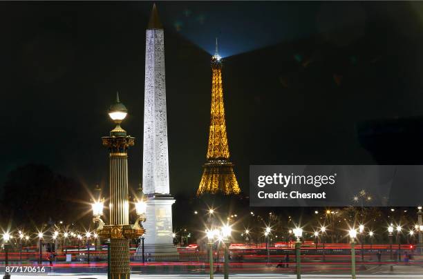 Luxor obelisk in the centre of 'Place de la Concorde' and the Eiffel Tower by night are seen during Christmas illuminations on November 21, 2017 in...