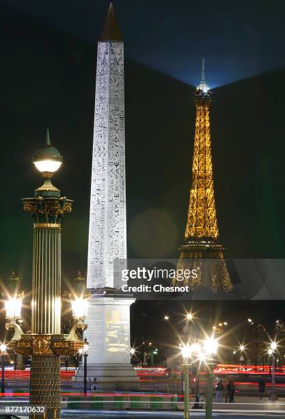 Luxor obelisk in the centre of 'Place de la Concorde' and the Eiffel Tower by night are seen during Christmas illuminations on November 21, 2017 in...