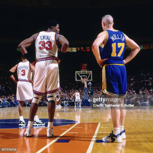 Chris Mullin of the Golden State Warriors stands with Patrick Ewing of the New York Knicks during a game played on March 3, 1996 at Madison Square...