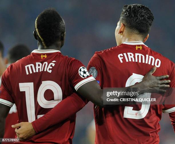 Liverpool's Brazilian midfielder Roberto Firmino celebrates with Liverpool's Senegalese midfielder Sadio Mane after scoring a goal on November 21,...