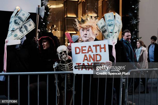 Tax cut protesters watch as New York City Mayor Bill de Blasio joins other Democratic officials, labor members and activists in front of Trump Tower...