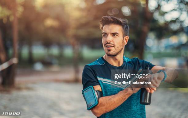 jogger en utilisant une montre intelligente - fitness armband photos et images de collection